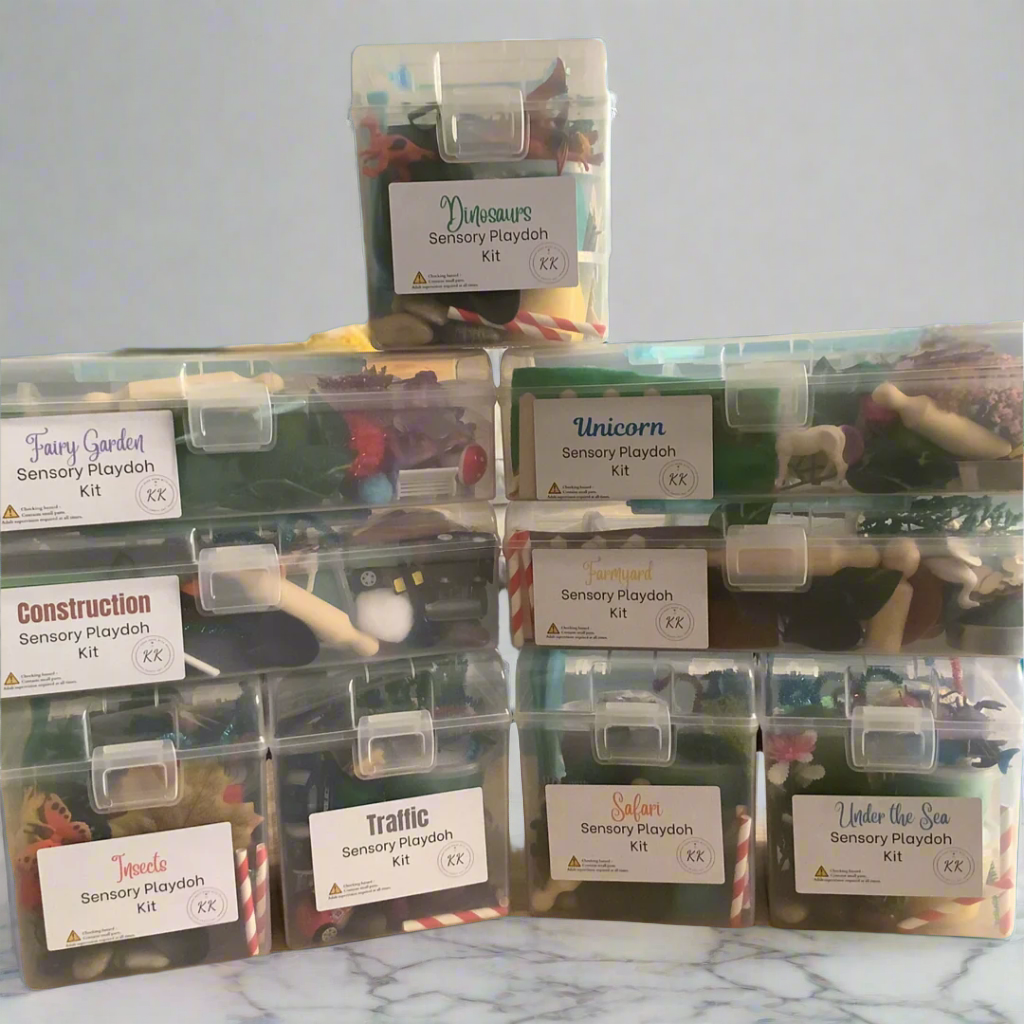 Showing the nine different themed sensory playdoh kits closed in their plastic carry containers with labels on a teal fabric background.