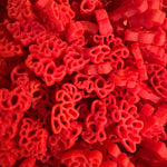 Some of Krafty Kat's Sensory Pasta being coloured red dinosaurs