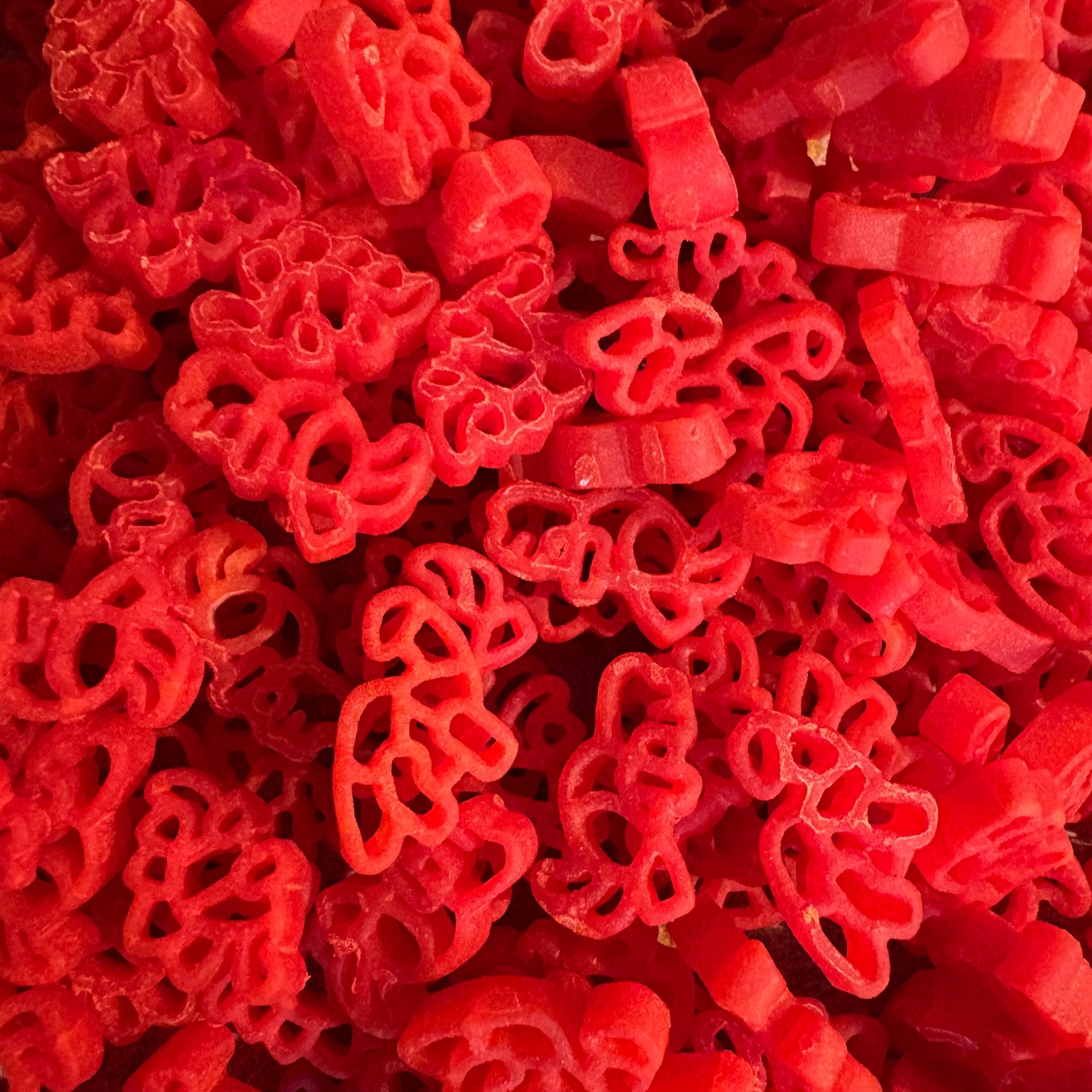 Some of Krafty Kat's Sensory Pasta being coloured red dinosaurs