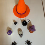 A collection of Halloween miniatures such as a mini orange witches hat, cauldron, black cat, skeleton head & spiders