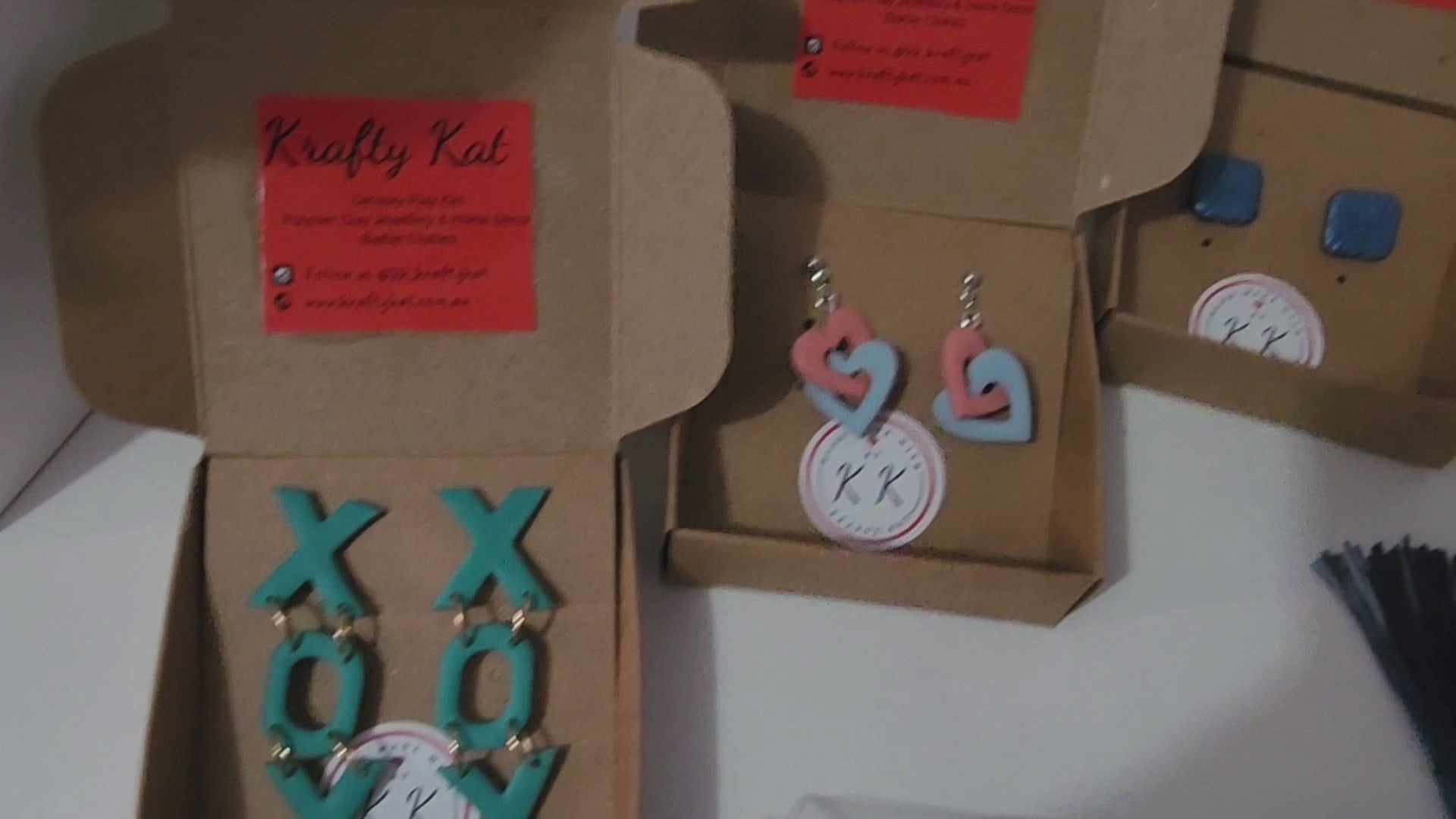 Load video: A video showing a selection of Krafty Kat items across all of the collections - hypoallergenic earrings - both studs and dangles, Sensory Playdoh Kits, Coasters, Bookmarks, Keyrings, Trinket Trays and Lanyards.